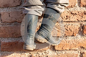 Child`s feet in boots climbing wall