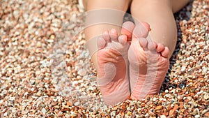 Child's feet on the pebbles beach