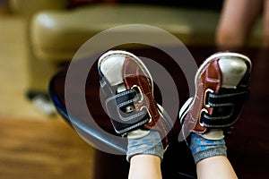 Child`s feet relaxed in bowling shoes