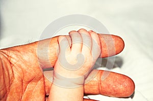 Child`s hand on adult hand