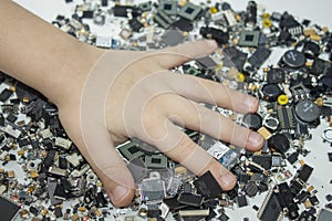 SMT components and a child hand in them. photo