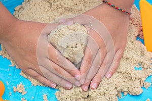 Child`s hand close up playing kinetic sand