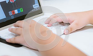 Child`s hand on computer keyboard play game