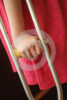 Child`s hand holding crutch