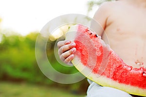 Child's hand holding a piece of watermelon