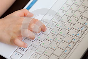 Child`s hand on the laptop keyboard