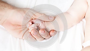 a child`s hand lies in a man`s hand. dad holds the baby`s hand. happy family concept. paternal love