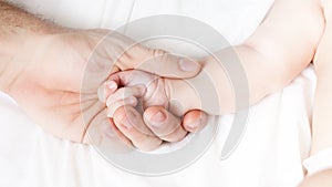 a child`s hand lies in a man`s hand. dad holds the baby`s hand. happy family concept. paternal love photo