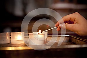 Child's hand lighting a candle in church photo