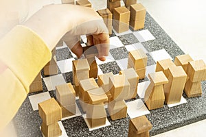 child's hand moving chess pieces on a marble chess board