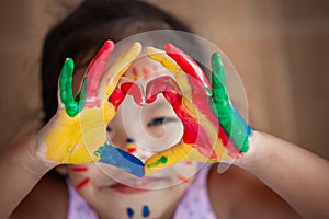 Child`s hand with painted colorful watercolor make heart shape