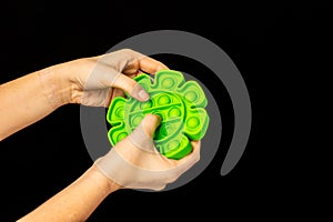 Child`s hand playing with a popping fidget toy