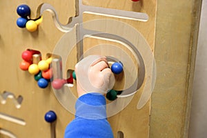 Child& x27;s hand plays with wooden puzzle