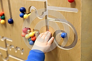 Child`s hand plays with wooden puzzle