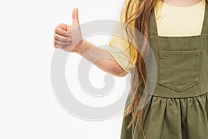 A child& x27;s hand shows the class. A girl in a yellow T-shirt and a green sundress. Space for text. Thumbs up.