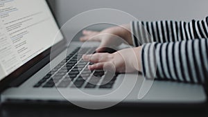 Child`s hand touching laptop keyboard