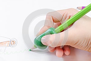 Child`s hand with writing tool for help by incorrect holding of pencil