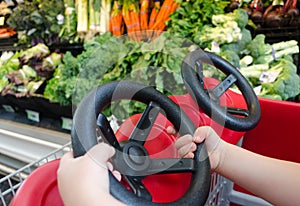 Child's hands driving shopping cart