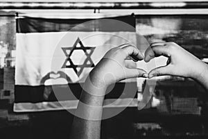 Child& x27;s Hands Form Heart on Israeli Flag with Sunlit Shadow.