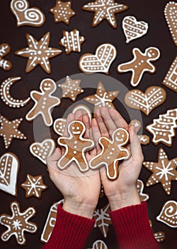 Child`s hands holding homemade two Gingerbread man cookies.