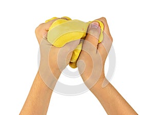 The child`s hands knead the yellow slime isolated on a white background.