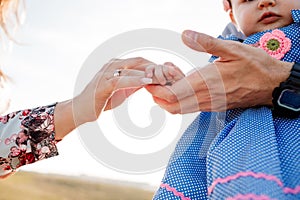 Child`s hands on mother and father hands. The concept of summer holiday. Mother`s, father`s, baby`s day. Family spending time