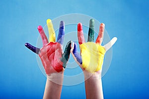 Child's hands painted with multicolored finger paints