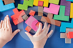 Child`s hands playing with colorful wooden blocks