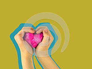 The child`s hands squeeze a heart-shaped slide on a yellow background. Collage style. A collage of hands of the child and the toy.