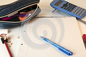 Child`s homeschooling desk with pencil case, pen, calculator and paper