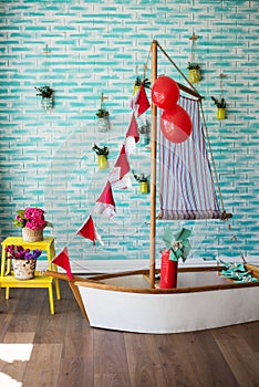 Child's photography studio interior. Ship with flags