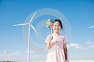 Child's playful exploration by windmills, little girl runs with pinwheels