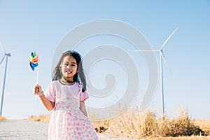 Child& x27;s playful exploration by windmills, little girl runs with pinwheels