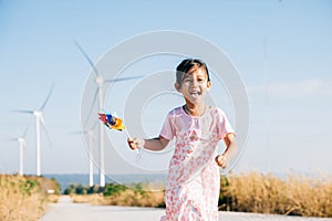 Child& x27;s playful exploration by windmills, little girl runs with pinwheels