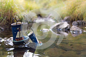Child's Rubber Boots in the River