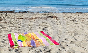 2 child`s sand pails and shovels on a striped beach towel at the ocean