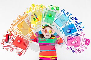 Child with school and drawing supplies. Student with book.