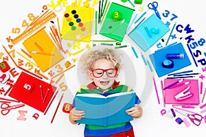 Child with school and drawing supplies. Student with book.