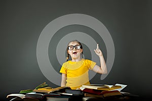 Child School Girl Pointing Blackboard at desk indoors, desk pile of books