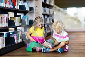 Child in school library. Kids reading books