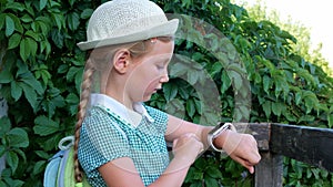 Child schooler using smartwatch outdoor park. Kid talking on vdeo call with parents on smartwatches. Smart wristwatch GPS tracker