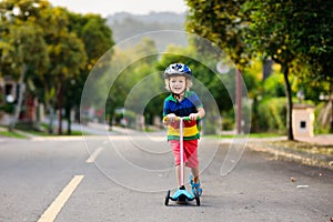 Child on scooter in summer. Kids skate