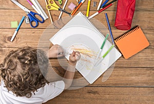 Child scribbling in a notebook. photo