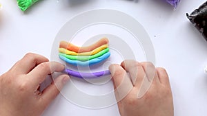 The child sculpts makes a rainbow from plasticine. Children's creativity.