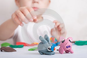 Child sculpts from plasticine pig and bunny photo