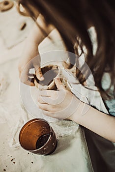 Child sculpts the product from raw clay