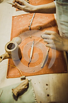 Child sculpts the product from raw clay