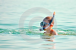 The child in the sea with the marine tube. scuba diving at sea. The boy in the glasses on the ocean