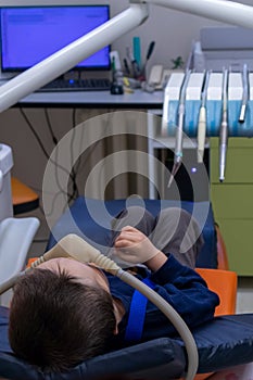 child with sedation tubes in dental chair. dental treatment under sedation