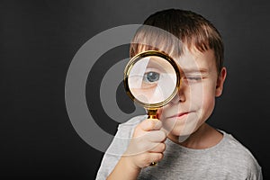 Child see through magnifying glass on the black backgrounds